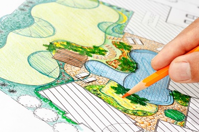Hand drawing a detailed landscape design plan with a pencil
